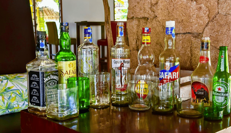 An assortment of drinking glasses with their respective glass bottle arranged at one of the chairs at the Bahari Beach hotel's lounge.