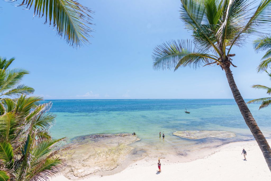 The indian ocean beach with a few people taking walks and swimming Mombasa, Nyali.