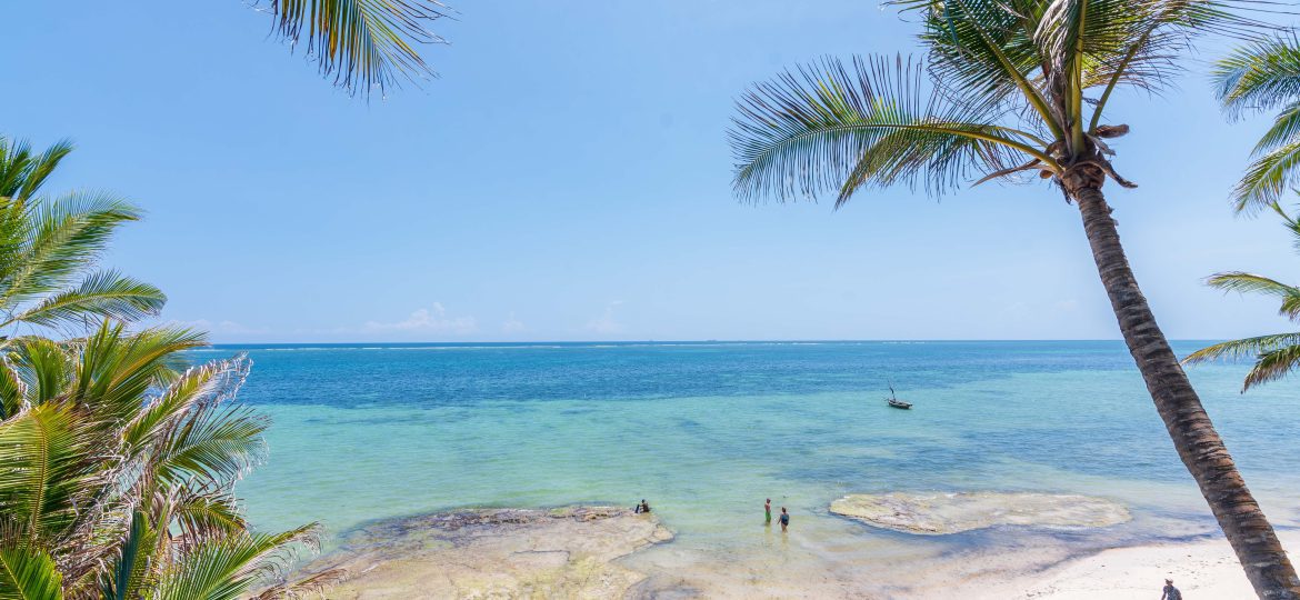 The indian ocean beach with a few people taking walks and swimming Mombasa, Nyali.