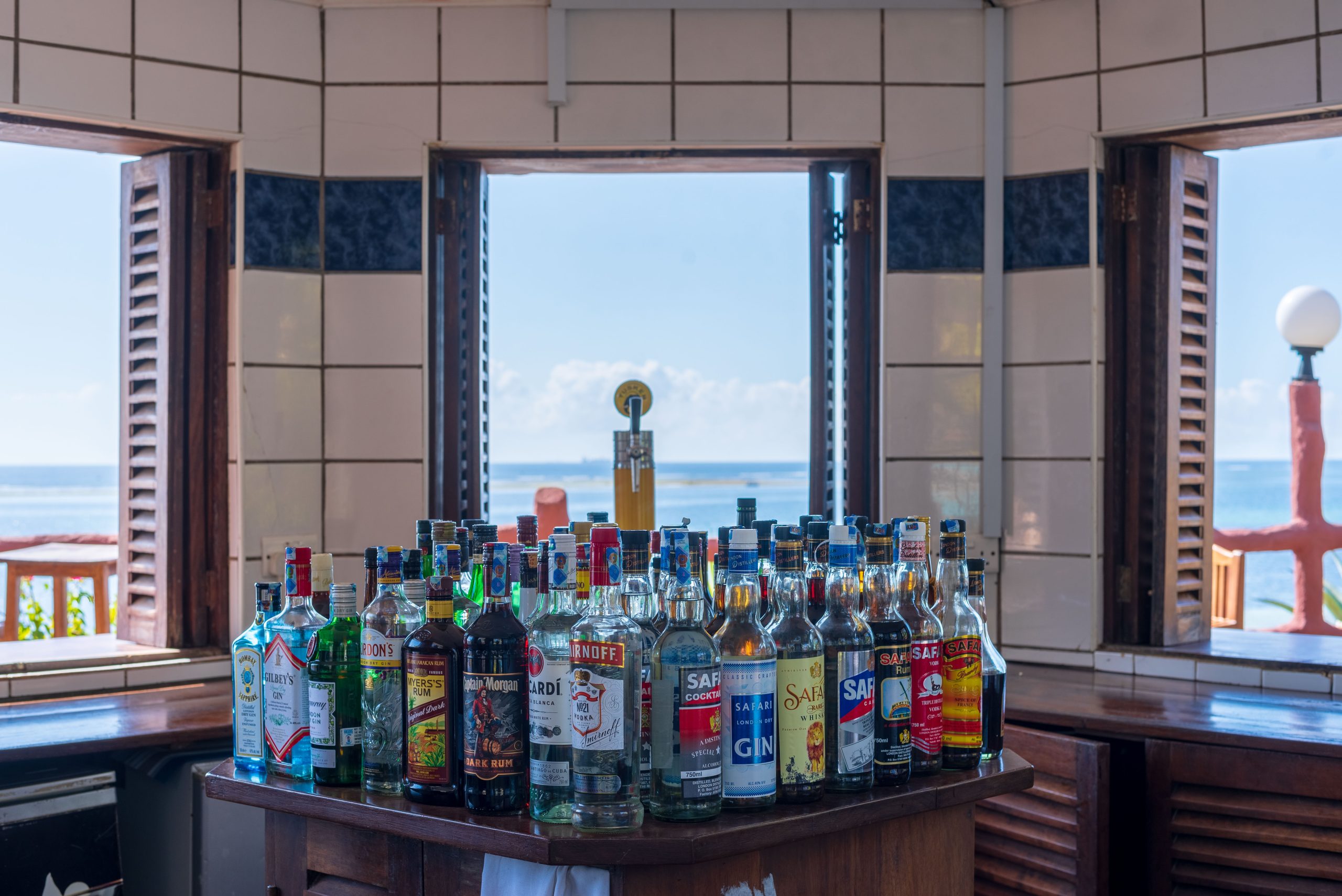 Inside Mikokoni bar with assortments of various alcoholic drinks on the counter at Bahari Beach Hotel, Nyali.