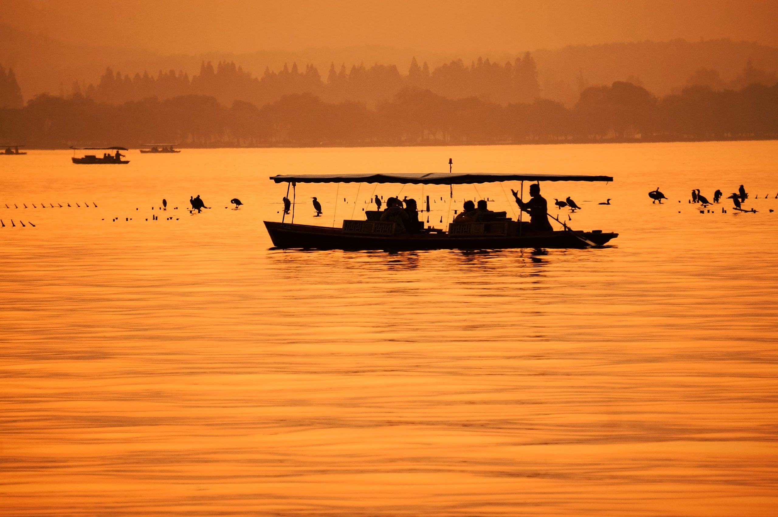 Orange landscape with fisherman in his boat.